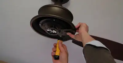 Electrician installing ceiling fan mounting bracket and fixture in Bellevue, NE