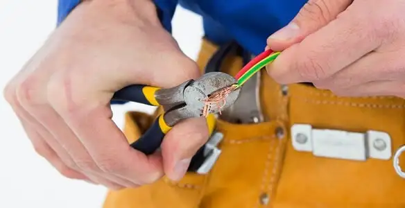 licensed electrician securing electrical wiring with professional tools during service work in Bellevue, NE