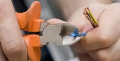 licensed electrician performing precise wire cutting and preparation during electrical service in Bellevue, NE