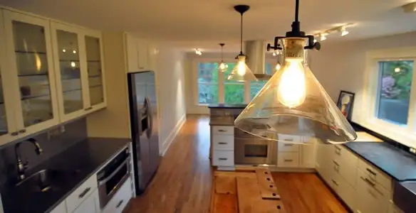 Residential electrician installing modern indoor light fixture in a home in Bellevue, NE