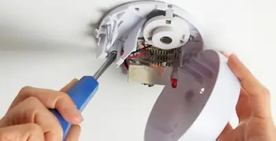 Certified technician wiring smoke detector during installation in Bellevue, NE